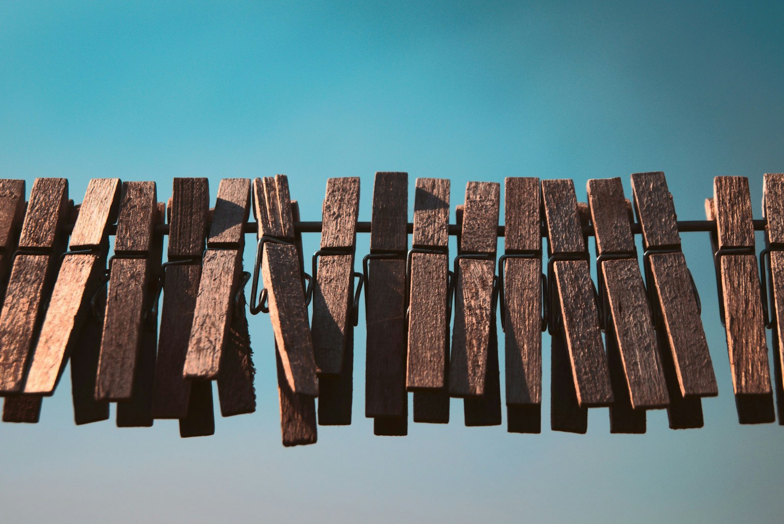 a close up of a wooden fence with a blue sky in the background