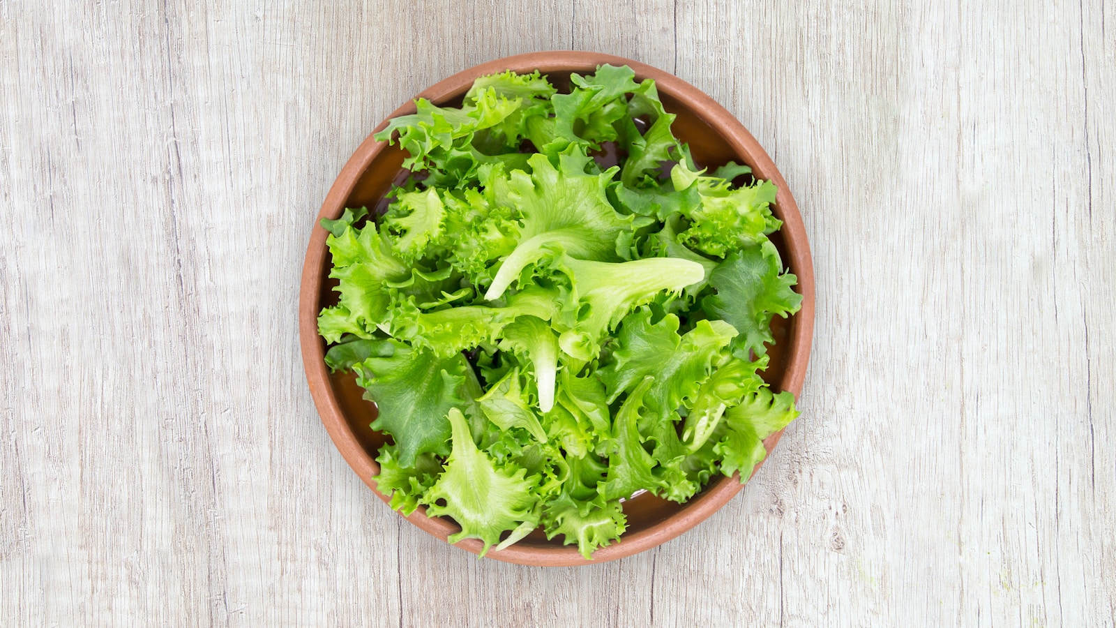 green vegetable on brown round plastic bowl