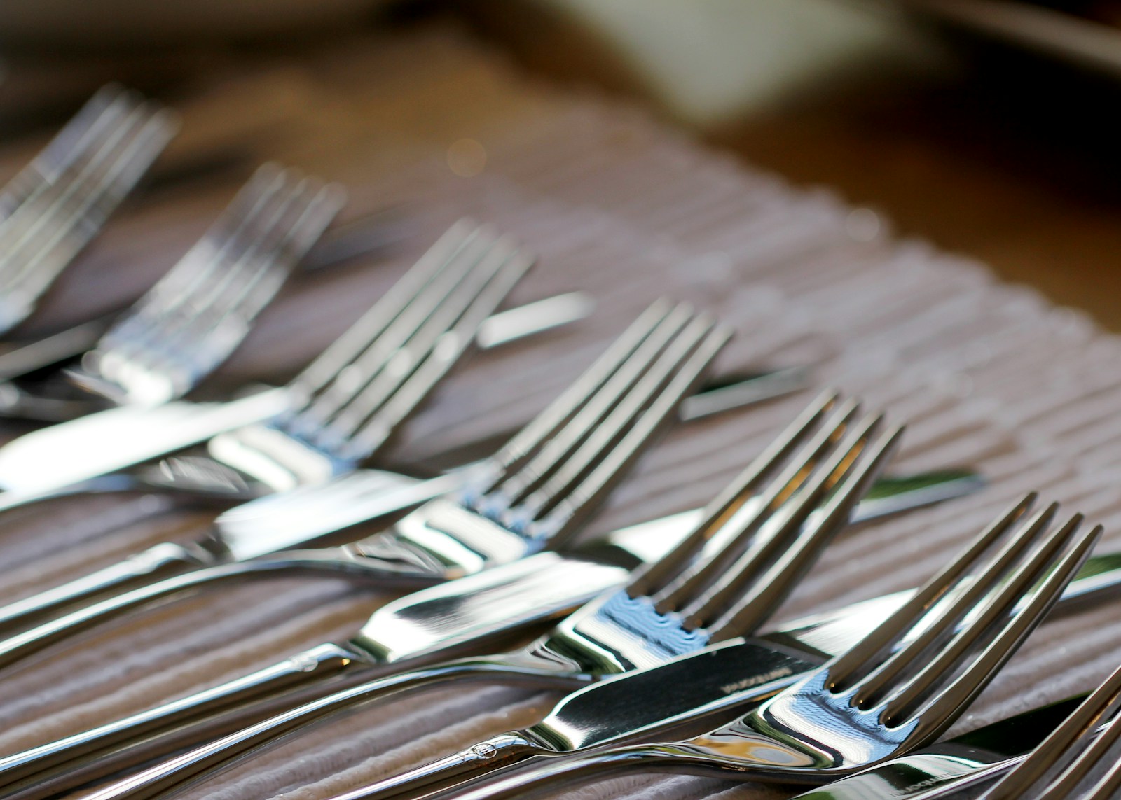 stainless steel fork lot on brown wooden table